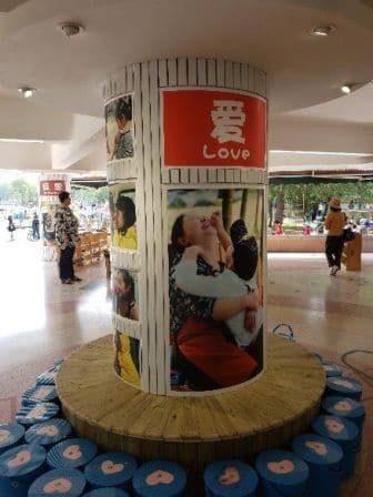 A pillar of people holding each other with the poster 'Love'