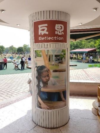 Pillar with an image of a young girl with a poster with the word 'Reflection'