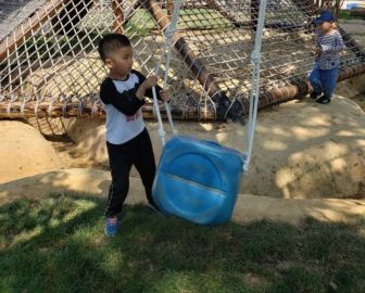 A young boy pulls a bucket