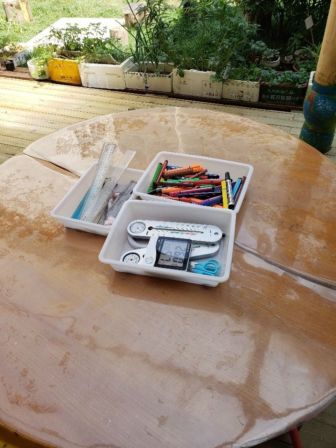A container of colored pencils and other tools