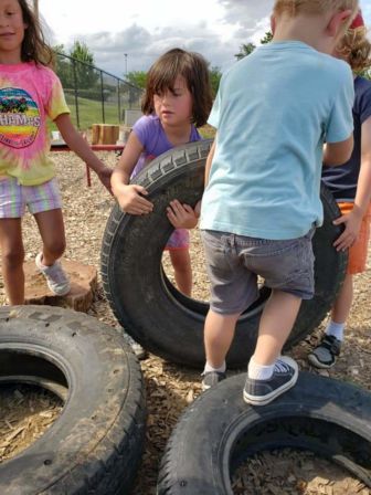 Children pick up large tires