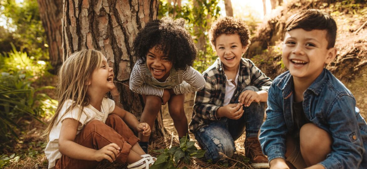 four kids playing in the woods