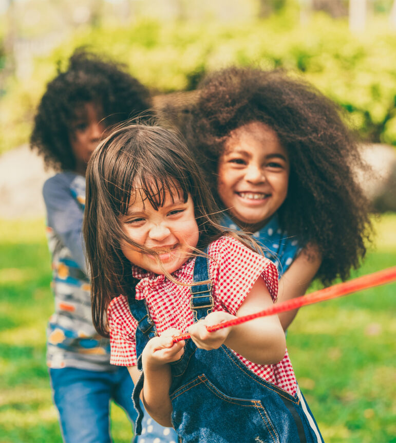 Three girls playing tug of war